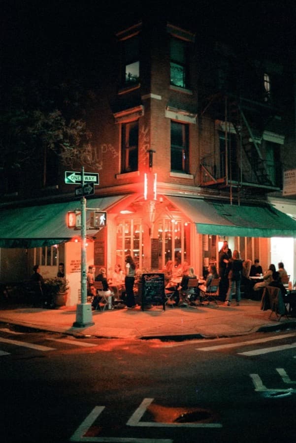 Guests outside a corner bar at night